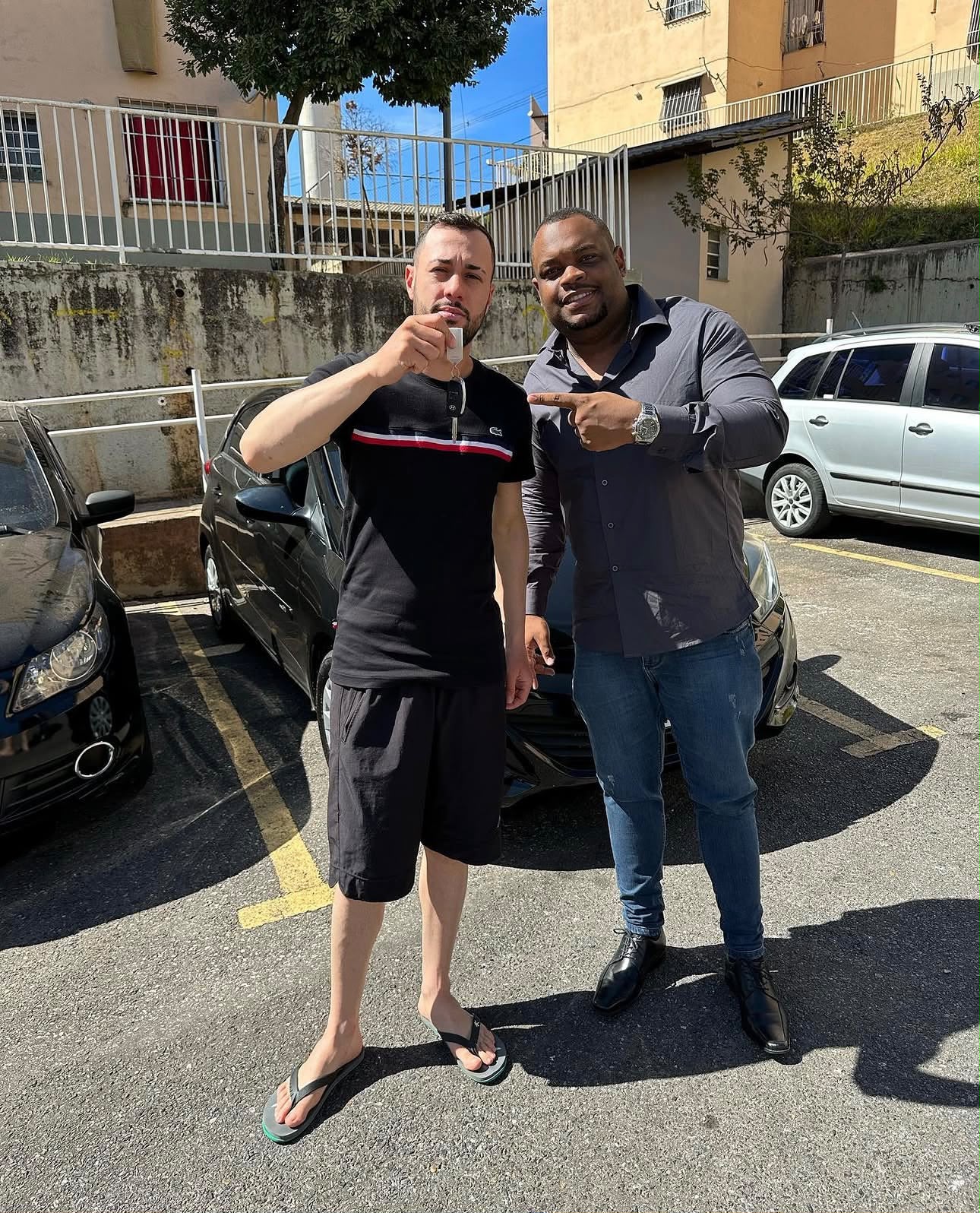 Cliente recebendo a chave do seu carro ao lado do consultor da FM Consórcios